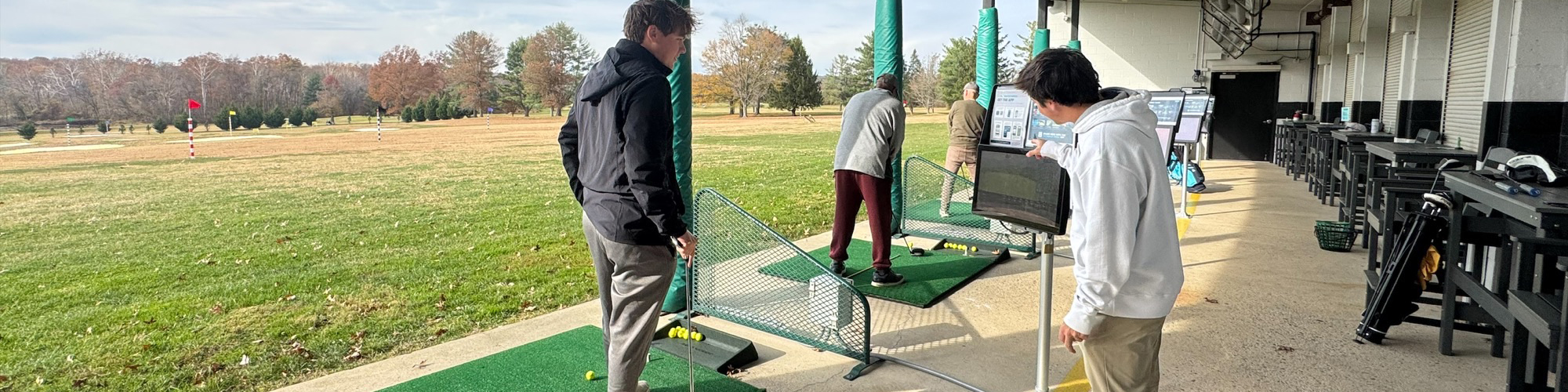 Golfers check their stats in a bay at the Treeline Range.